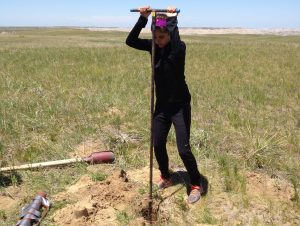 NSU marine biology major Victoria Pecci uses a bucket auger to get a sample of sand from an inactive sand dune in the Badlands in southwestern South Dakota.